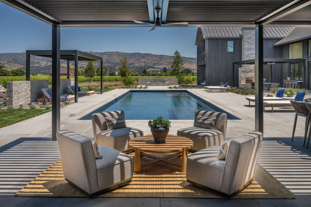 outdoor seating area with pool and mountain views