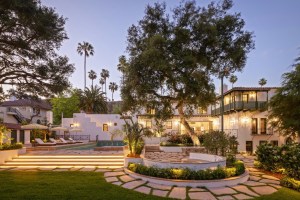 Spanish Colonial style home with pool, lush landscaping, and winding paths