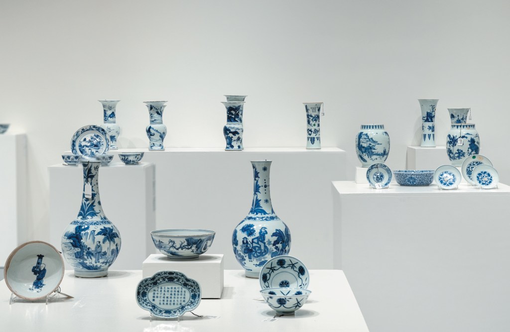 Asian art exhibition featuring various blue and white vases, plates, and bowls