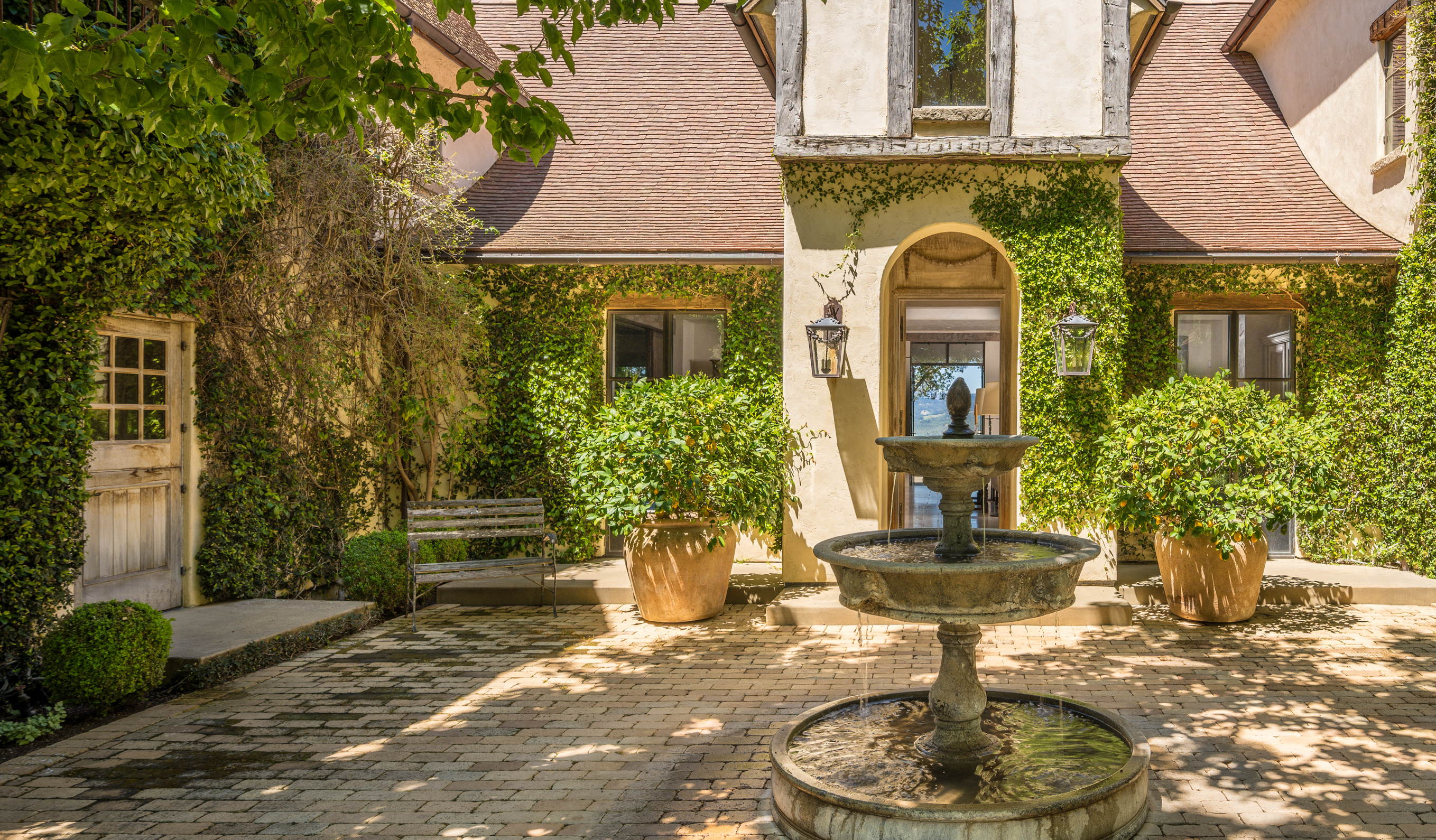 vine covered home exterior with fountain