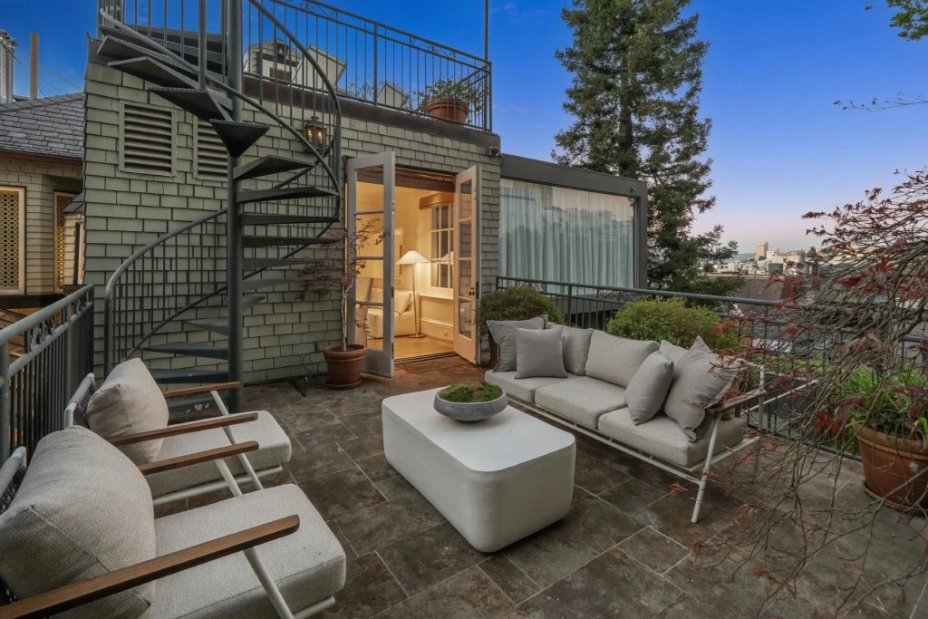 french doors lead to an outdoor terrace with spiral staircase leading to rooftop patio