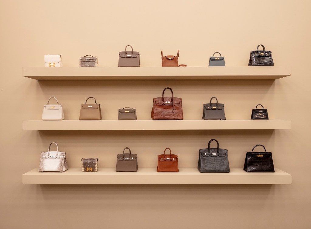 brown partition with shelves featuring luxury handbags