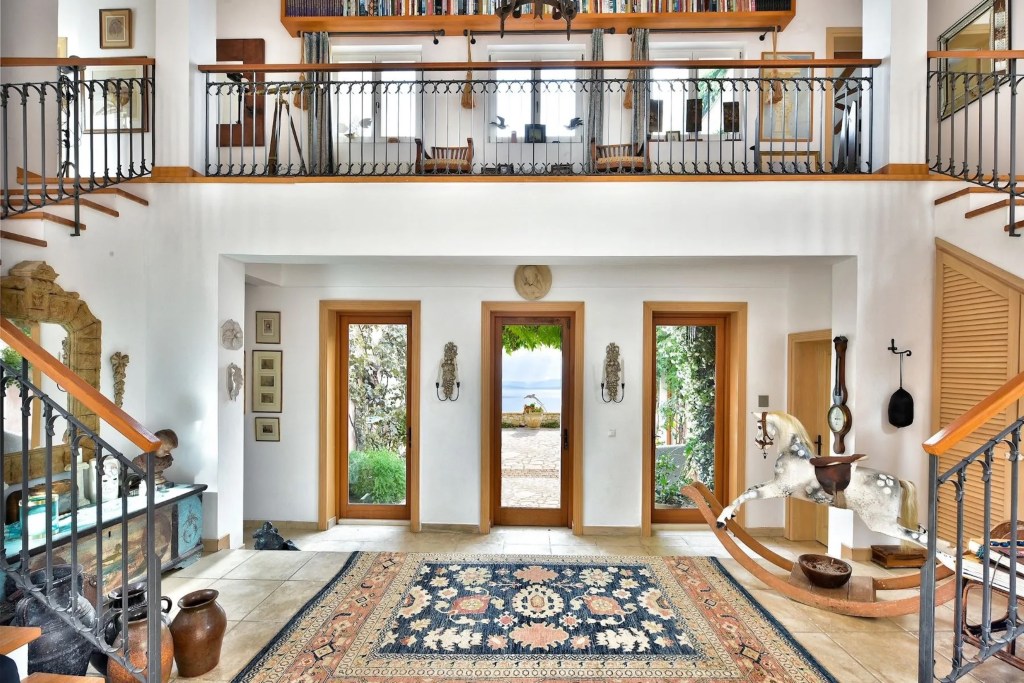 grand entryway with rug and dual staircases
