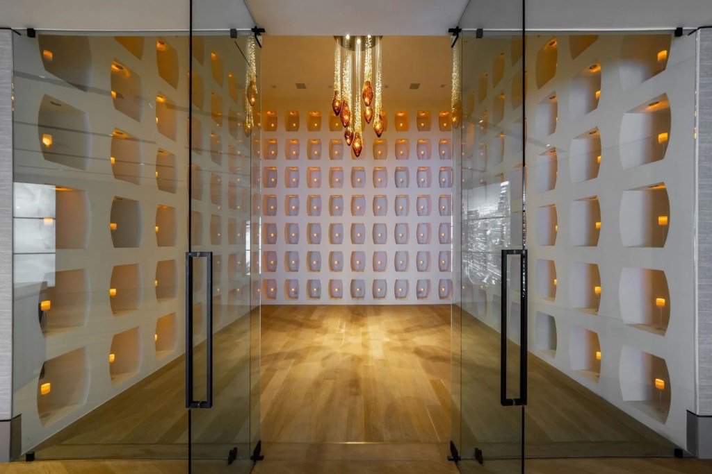 grand entryway with chandelier and lighted walls