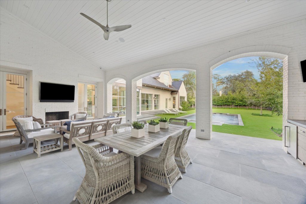 outdoor dining and lounging area, with pool in the background