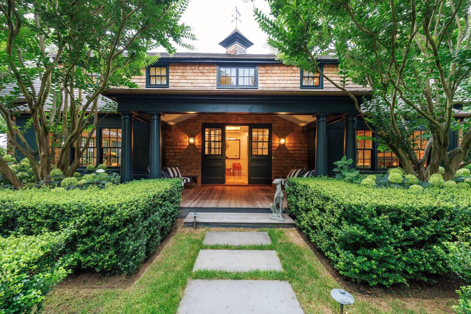 East Hampton home with open door and hedges