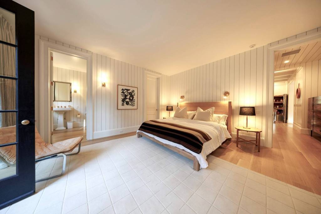 white paneled bedroom with en suite bathroom and patio door