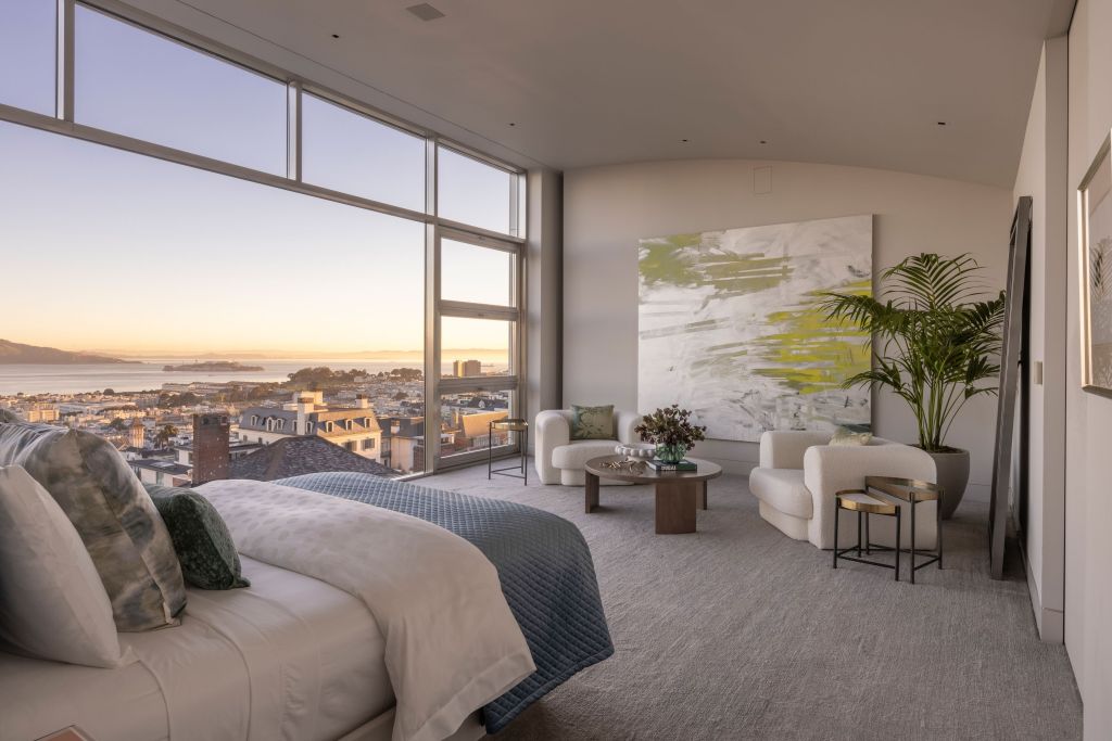 primary suite with sitting area and floor-to-ceiling windows showing bay and city views