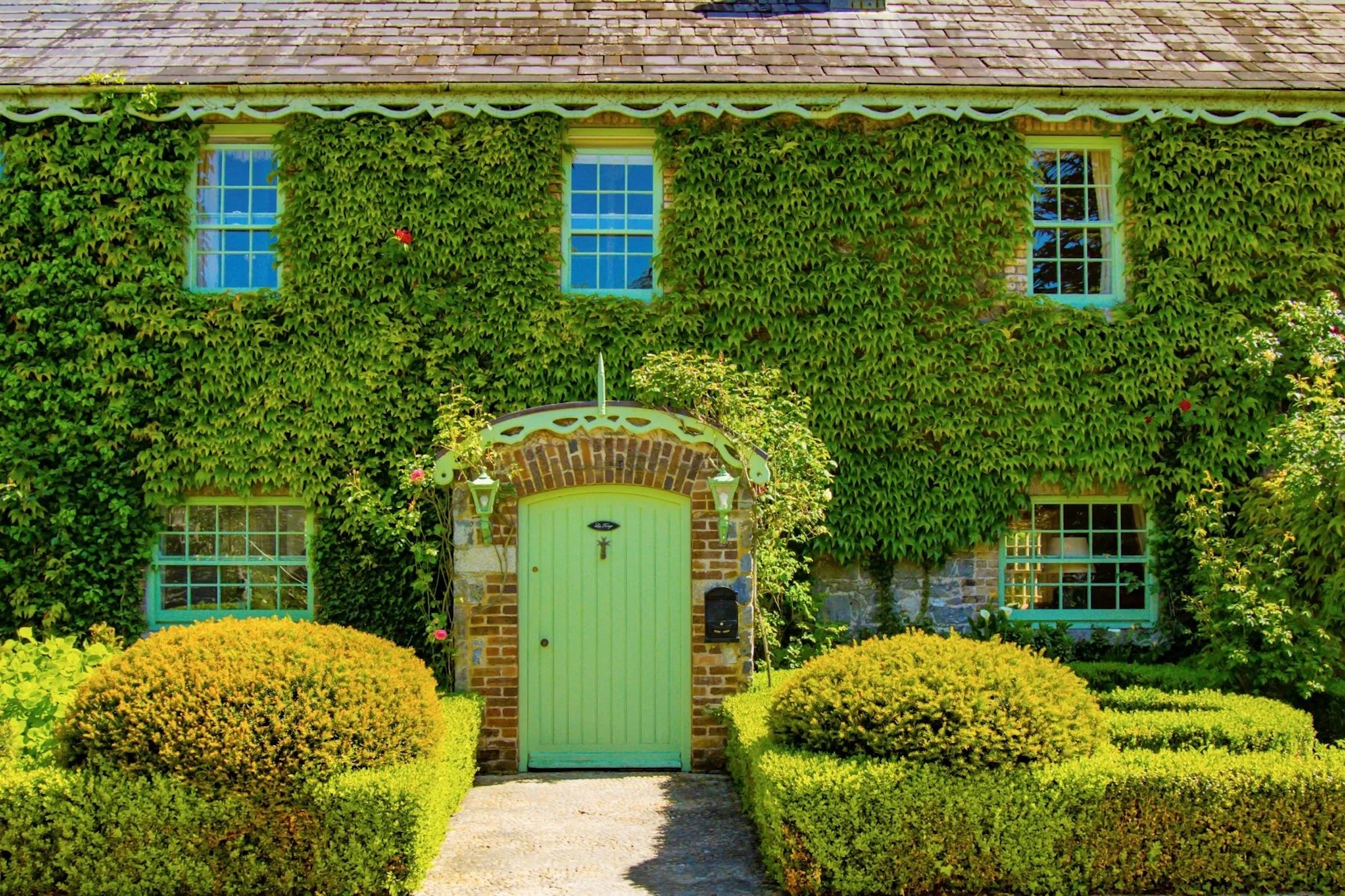 ivy-covered cottage exterior with green door
