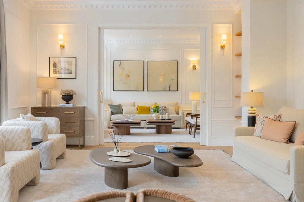 white sitting room in Madrid penthouse opening to formal living room 