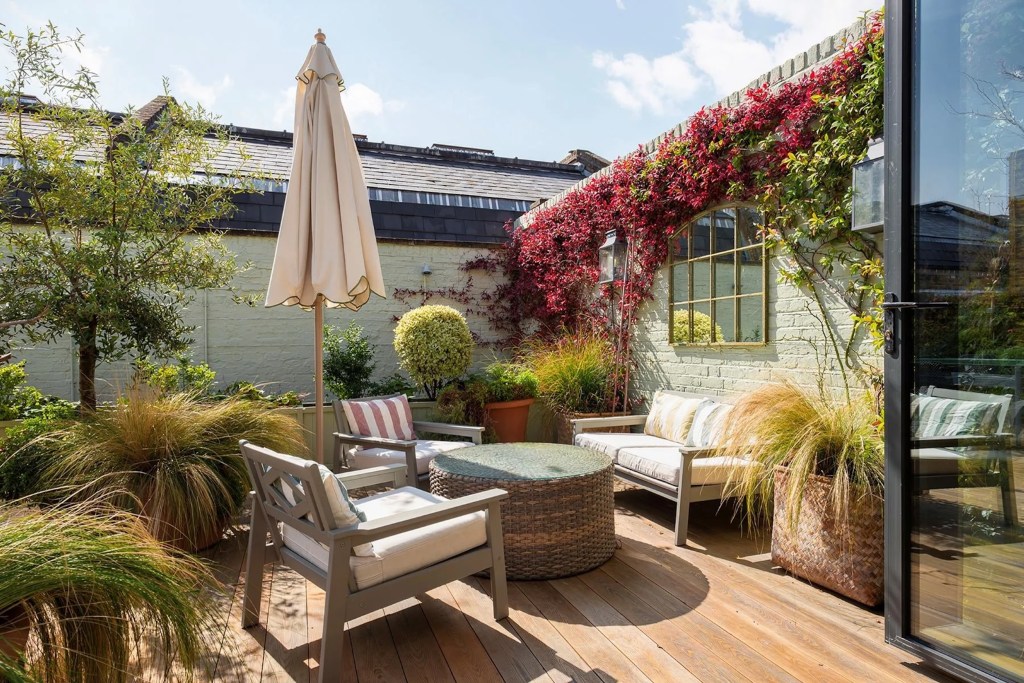 Outdoor sitting area surrounded by greenery in Notting Hill home