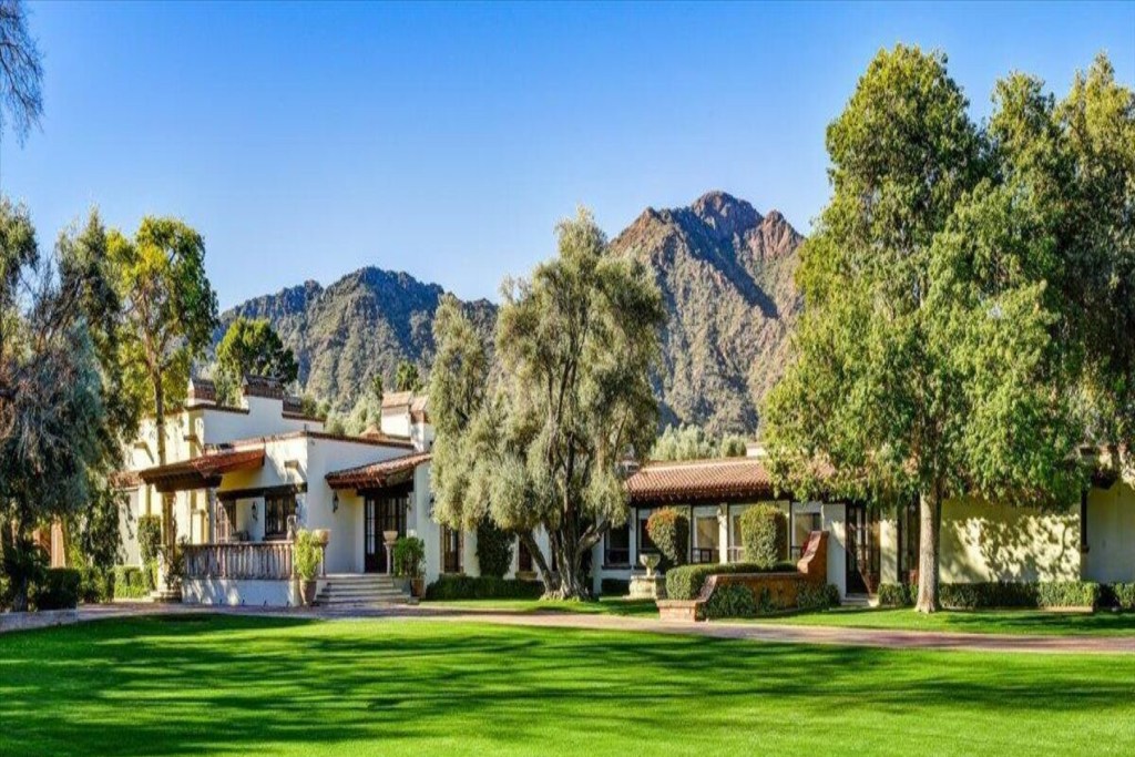 Hacienda, grounds, and trees with mountains in the background. Paradise Valley, Arizona.
