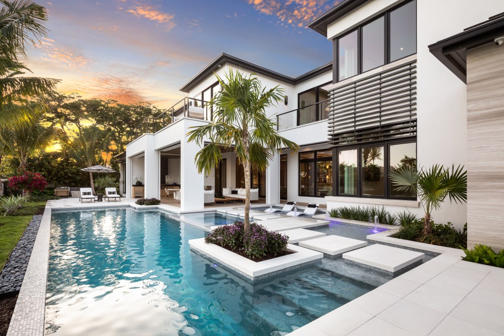 exterior of contemporary home in Naples, Florida with pool and lounge seating