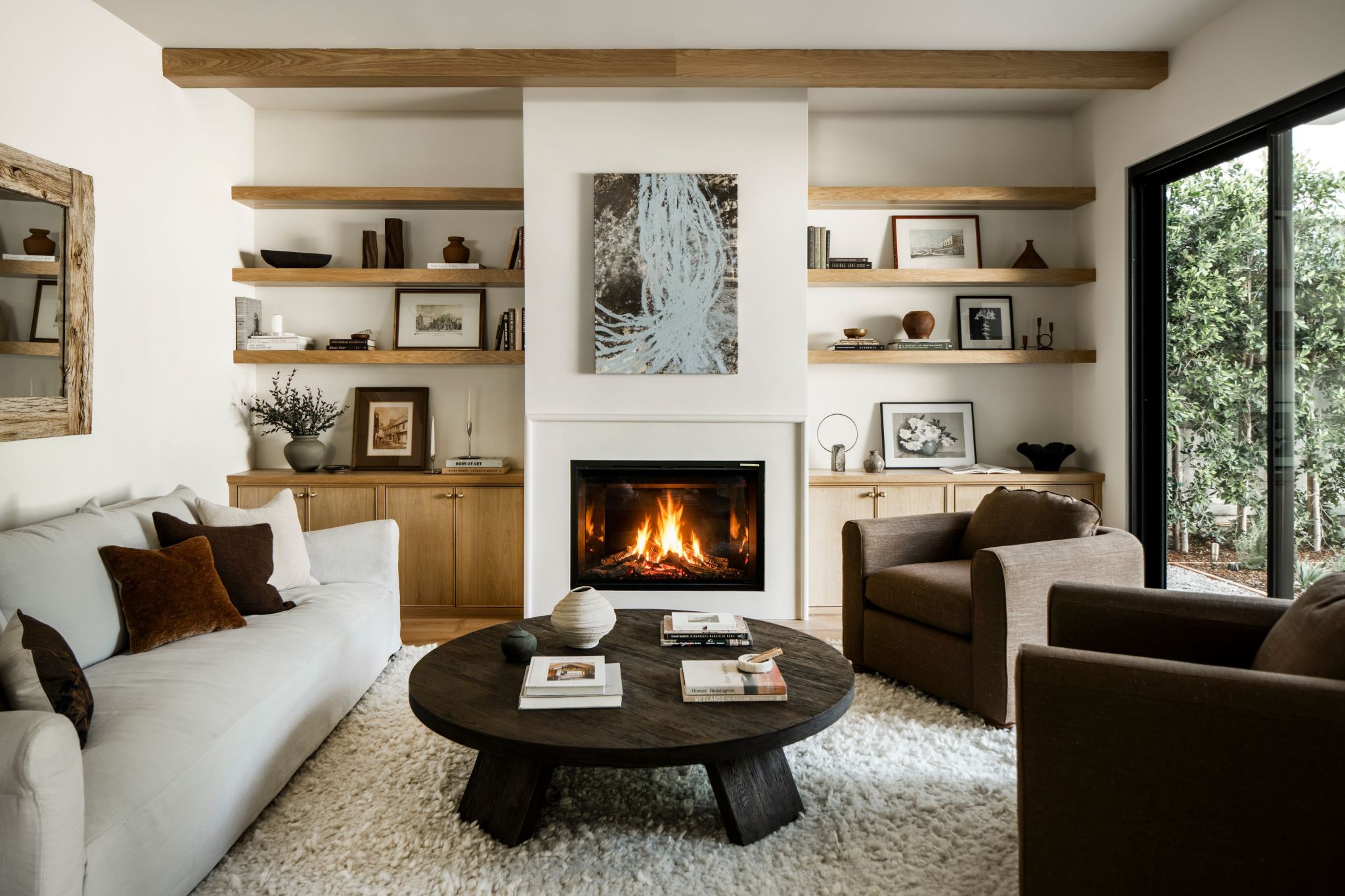 living room with organic design, floating shelving, and fireplace