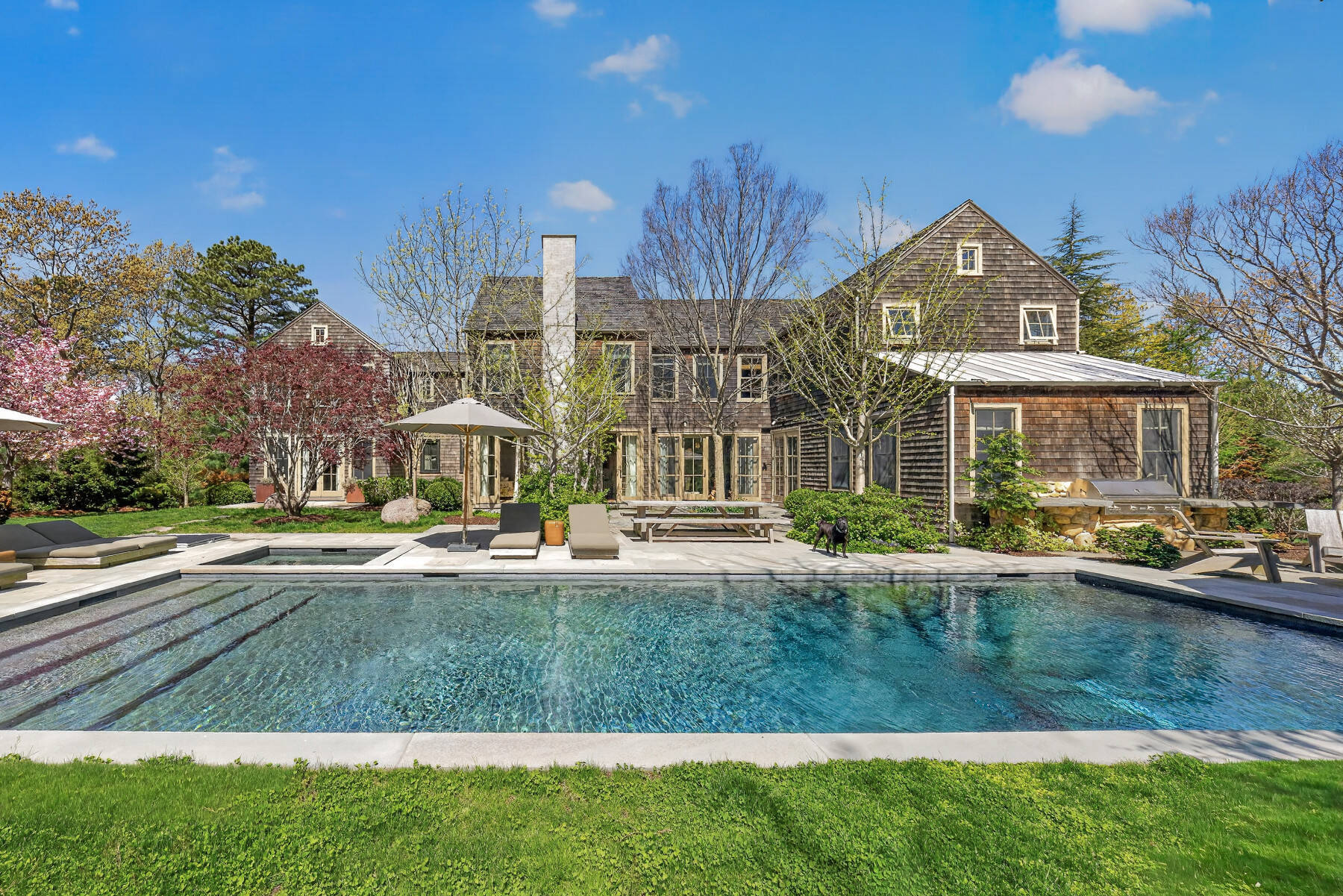 Exterior of shingle-style home with pool