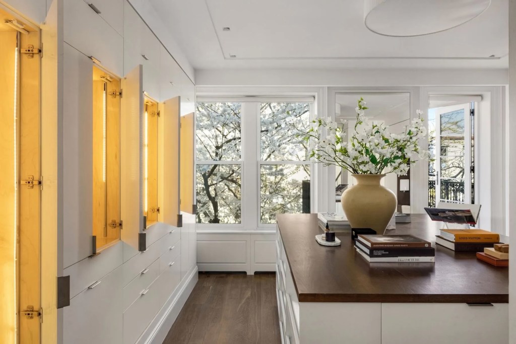 bright white dressing room in Brooklyn home with open, lit cabinets
