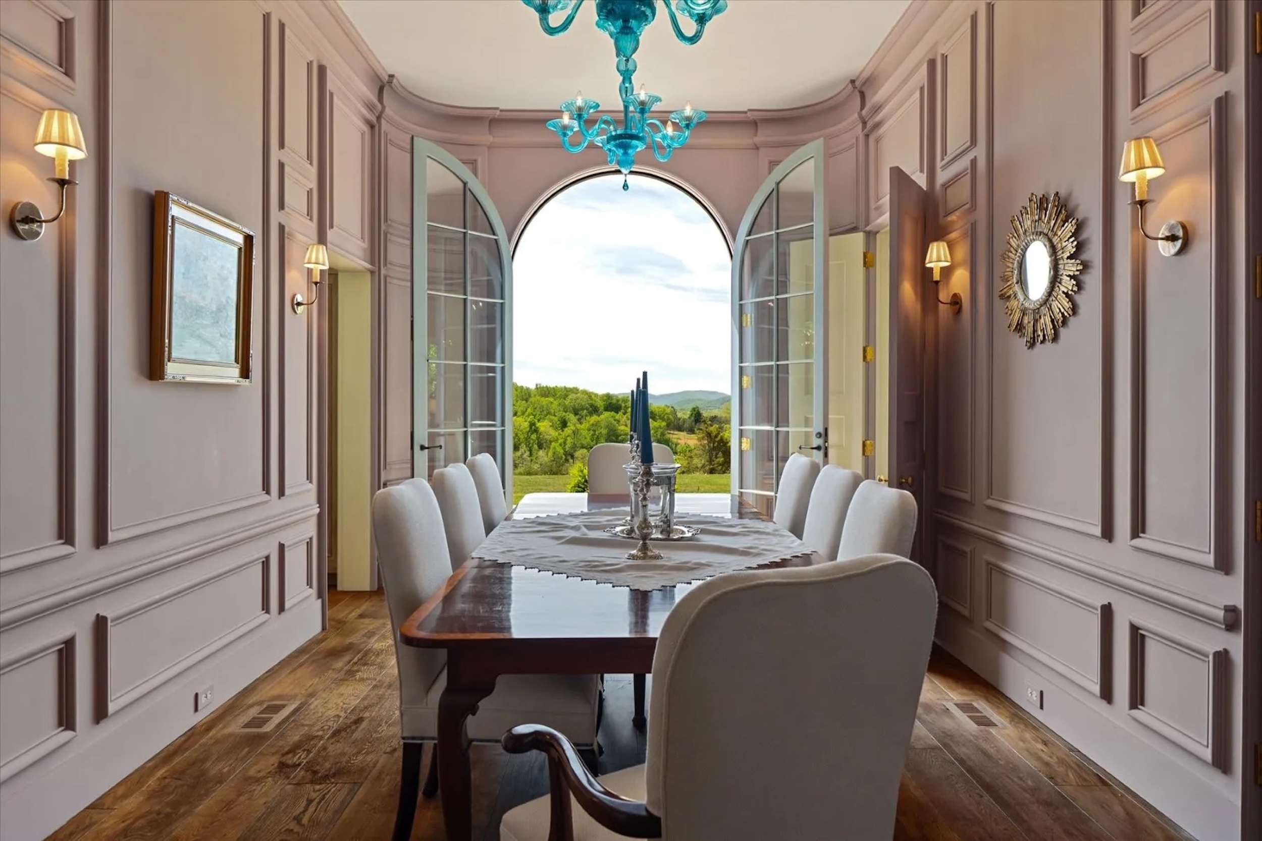 dining room with lilac walls, turquoise chandelier, and open French doors