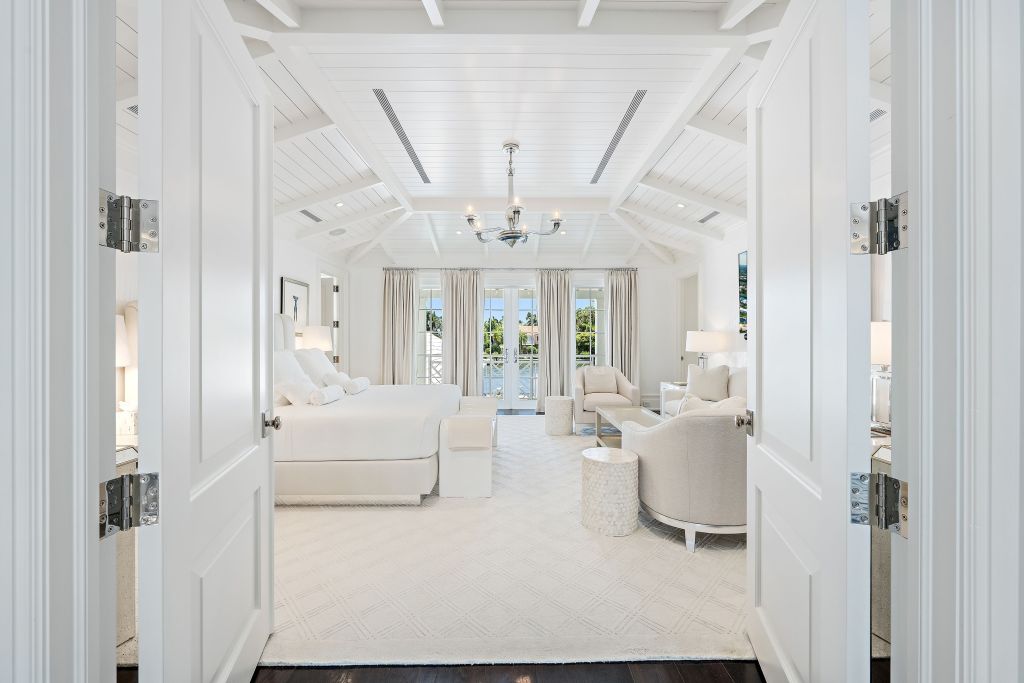 all white bedroom in Palm Beach home with french doors leading to balcony