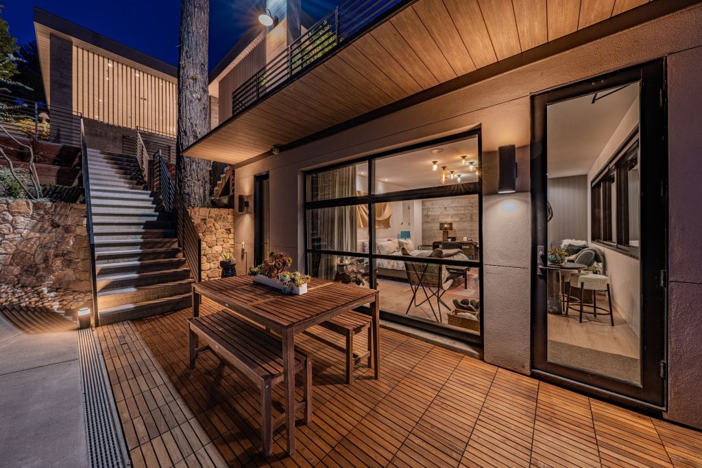 stairs leading to patio outside of bedroom with glass door and windows