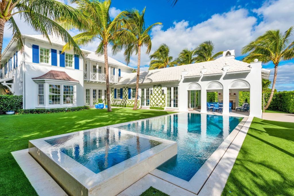 Backyard of Palm Beach home with pool and covered loggia