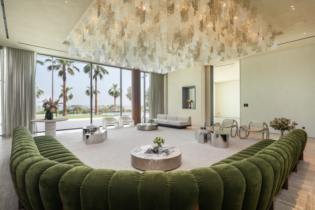 Living room with floor-toceiling windows looking out to Palm trees in Dubai, United Arab Emirates
