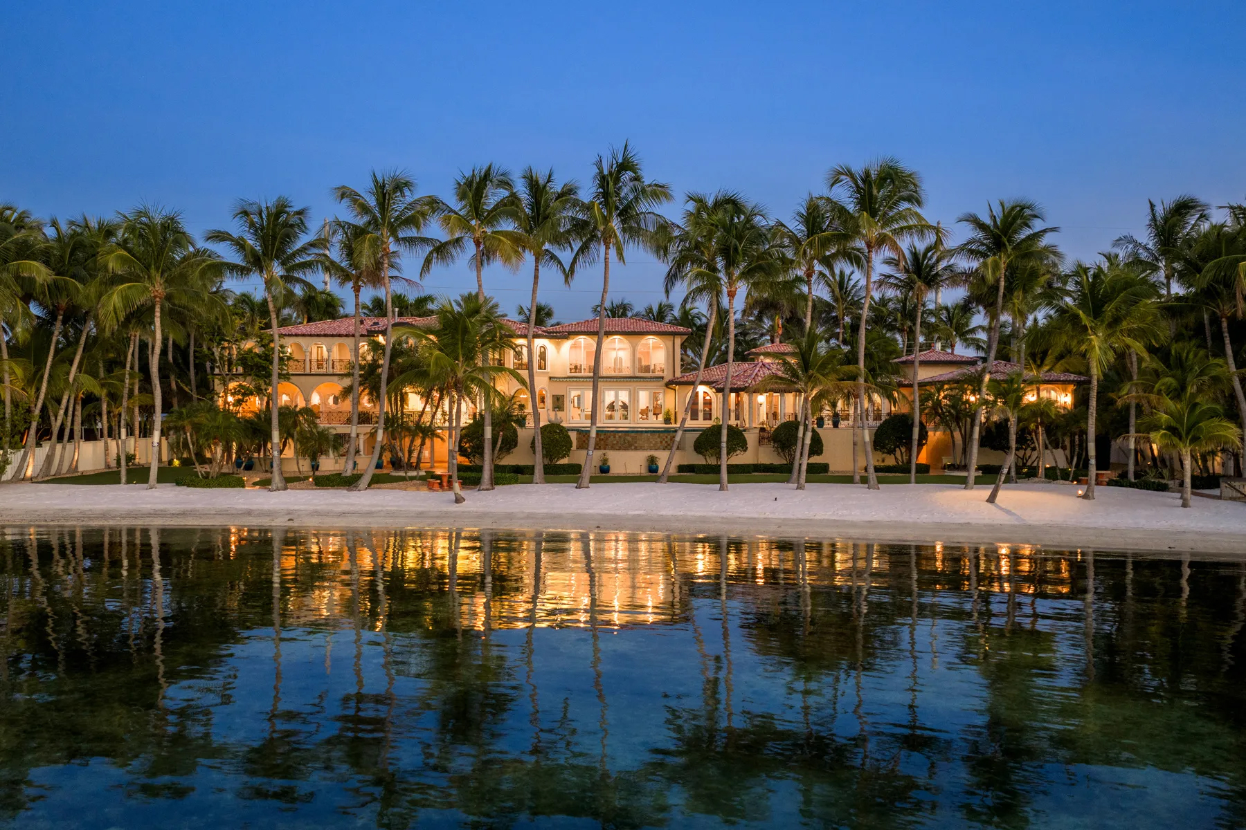 Beachfront mediterranean-style villa in Islamorada, Florida, surrounded by Palm trees.