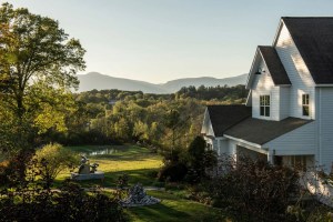 White country hosue in Germantown, new York, with views of a pond and hills in the background.