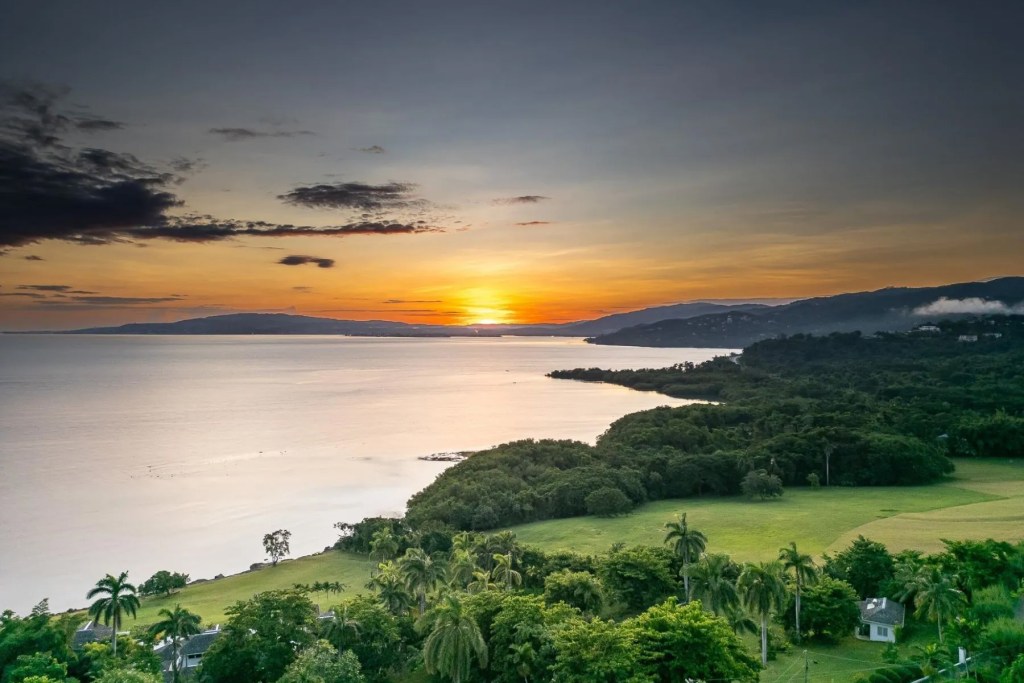 View from Hanover, Jamaica across water and coastline at sunset.