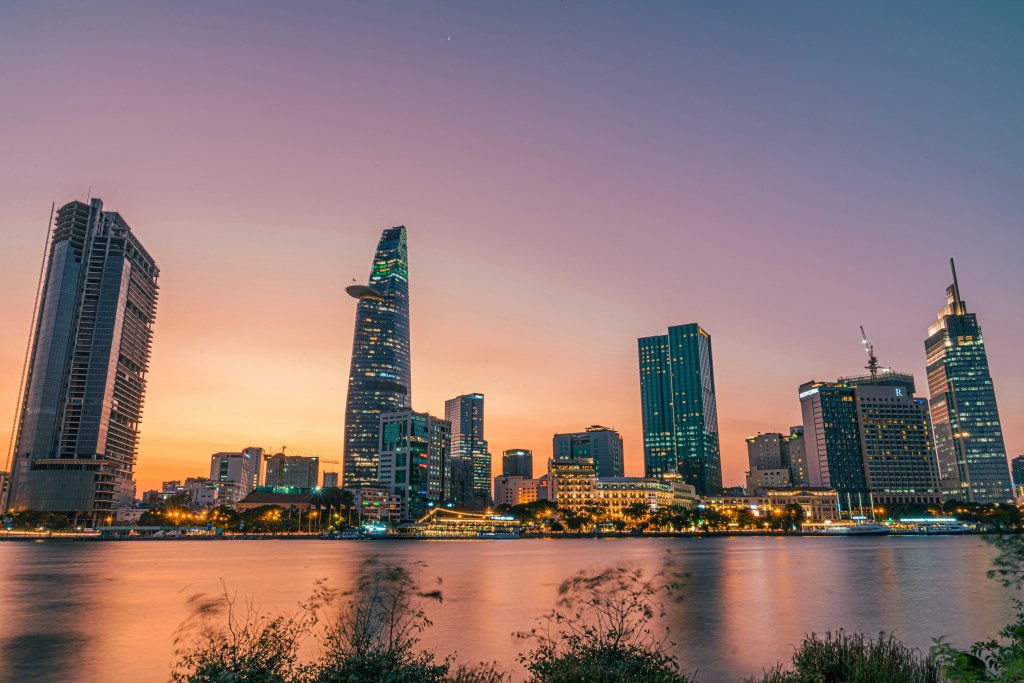 Sunset view of Ho Chi Minh City, Vietnam with water in the foreground.