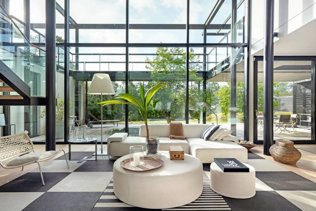 light-filled interiors with glass walls and white modern furnishings in Finnish villa