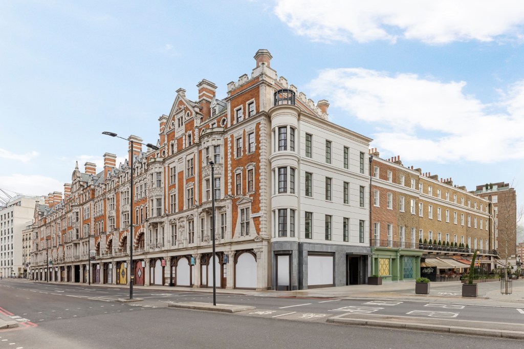 Prominent corner building combining restored historic architecture with contemporary design, located along a wide urban boulevard.