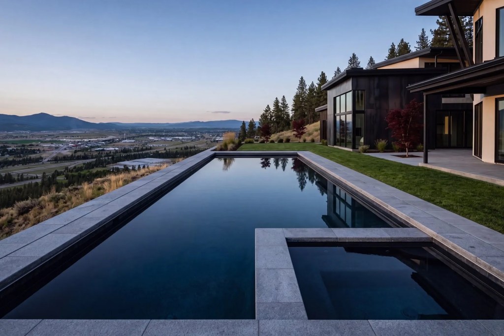 Elegant double-height living room with floor-to-ceiling windows showcasing panoramic sea views, modern furnishings, and a bright open design. Liberty Lake, Washington.