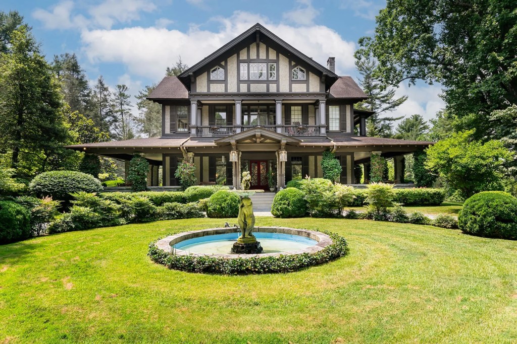 home in North Carolina with wrap around veranda, landscaping, and fountain