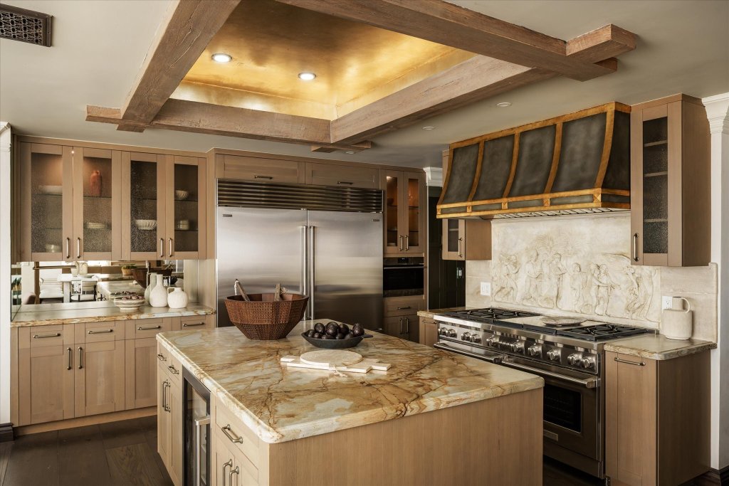 chefs kitchen in Wilshire Blvd penthouse in Los Angeles with marble countertops and sculpted backsplash