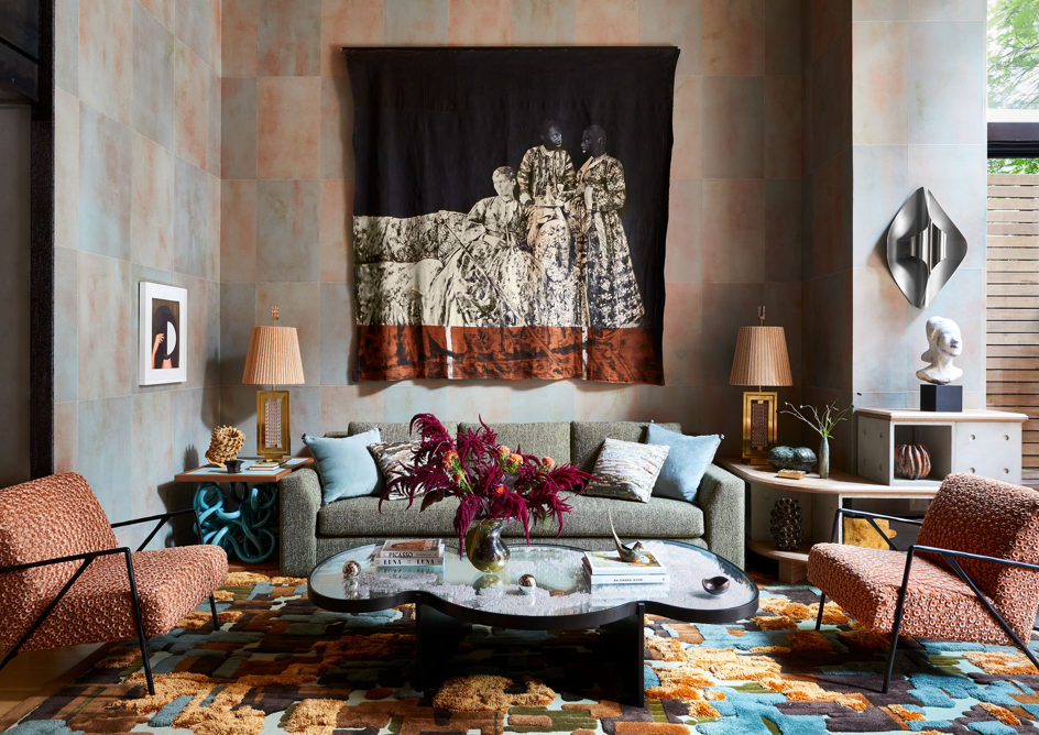 eclectic salon in Greenwich Village townhouse with soft seating, curved, sculptural coffee table, paneled walls, and artistic accent tables and lighting, with large tapestry on the wall