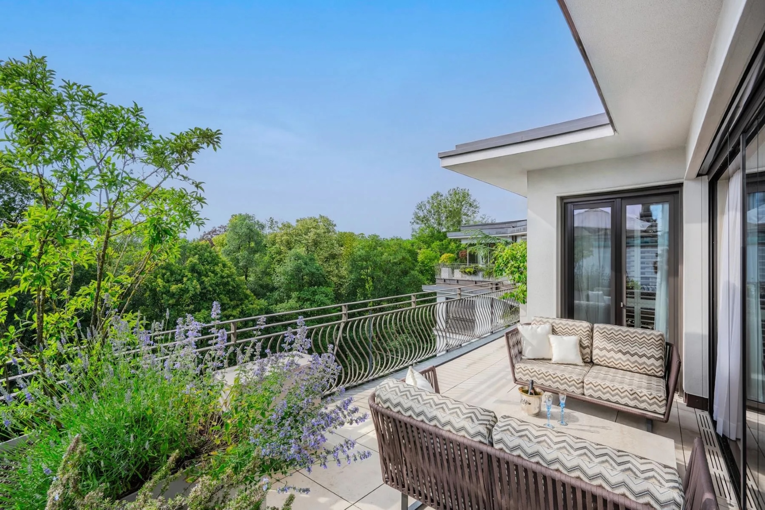 exterior of Munich penthouse balcony overlooking the treetops of Munich's English Garden
